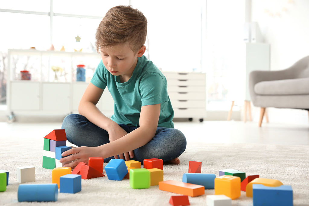 Child playing with cubes and lining them up, exhibiting stereotyped behavior in Autism
