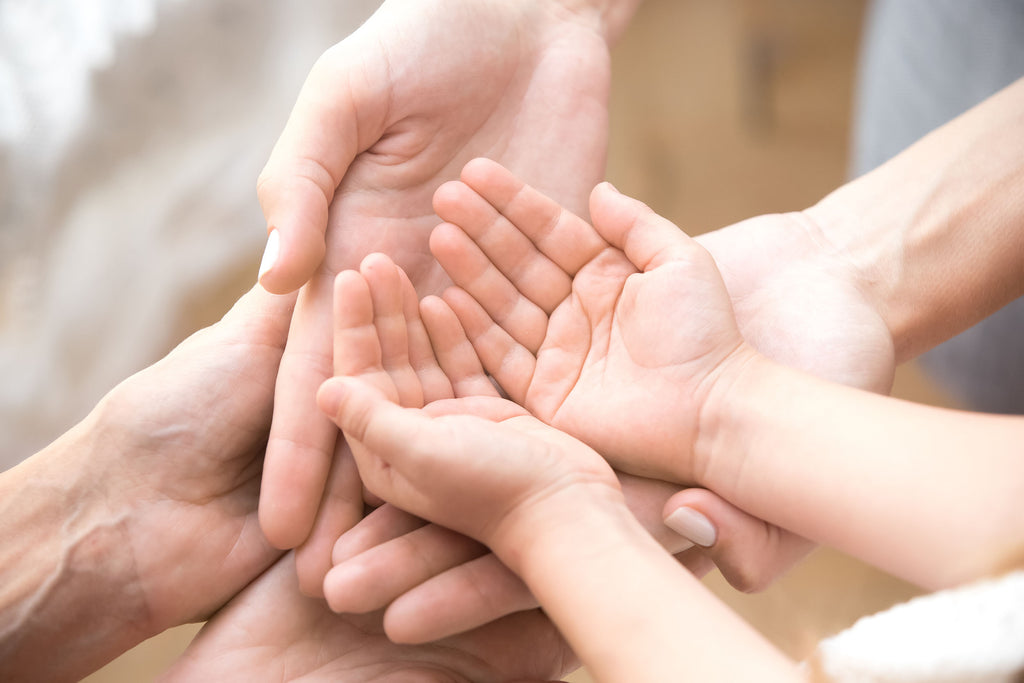 Three generations of hands represent the journey of solving Autism and understanding it. 